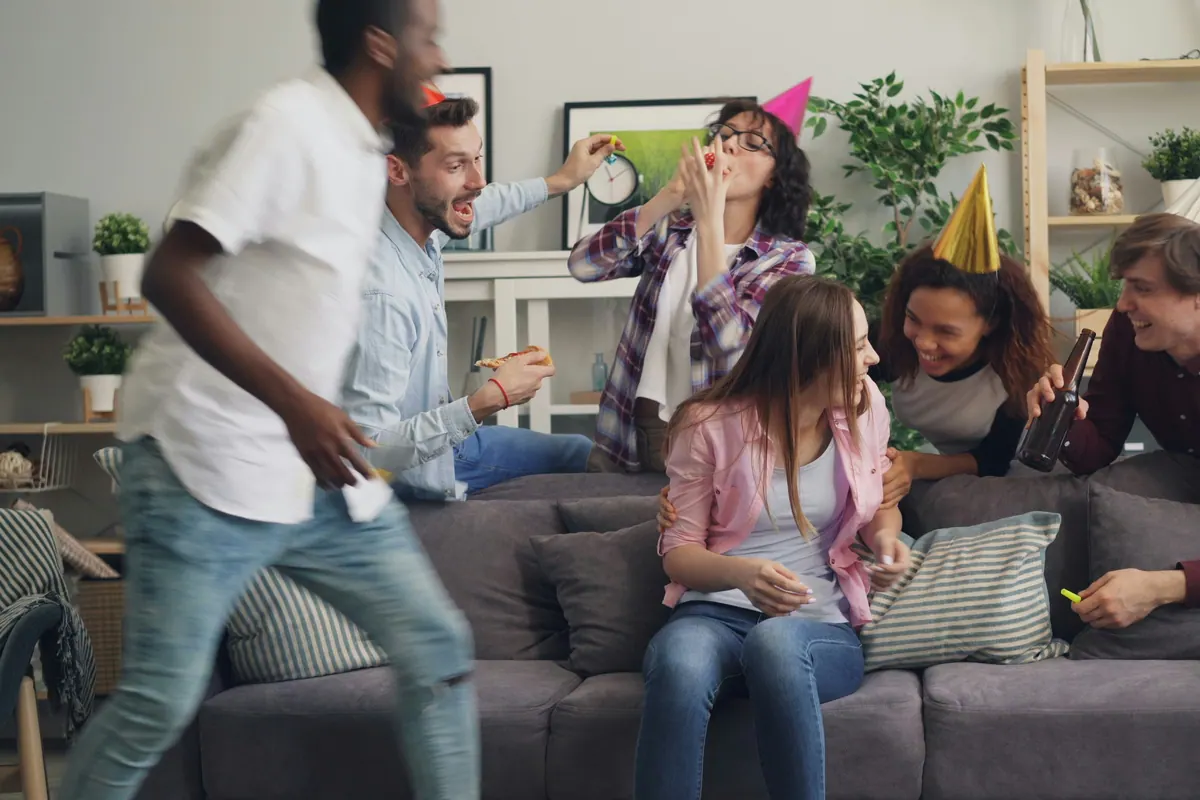 Groep vrienden speelt een actieve opdracht in de woonkamer