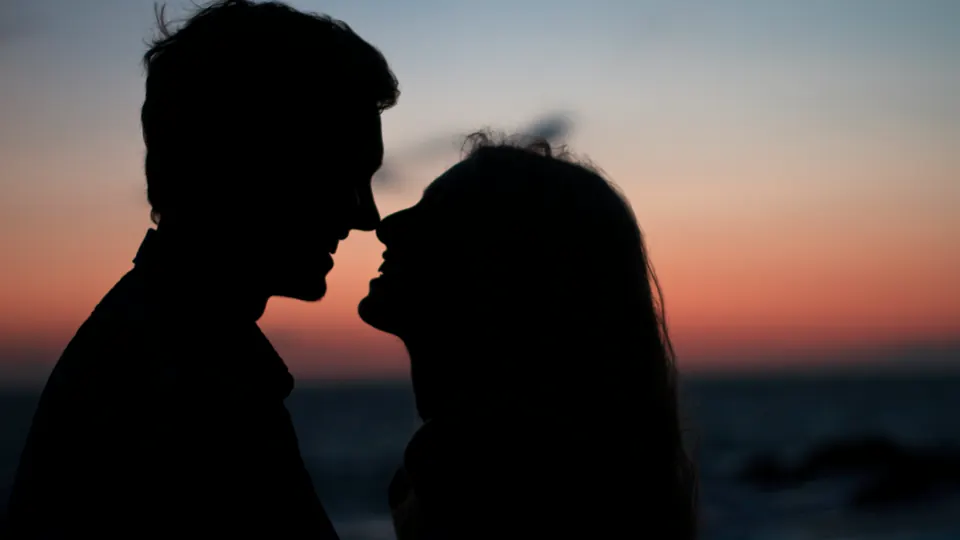 Two adults share a quiet moment at sunset