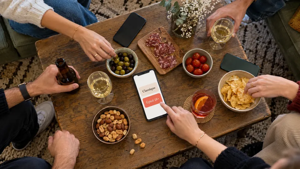 Un téléphone sur la table affiche les packs de questions