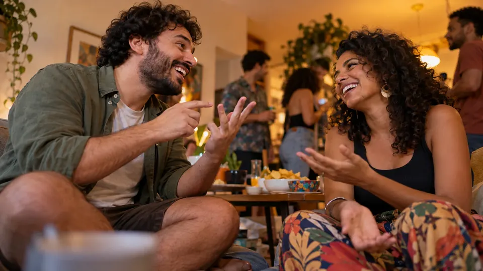 Dois amigos riem e discutem um dilema