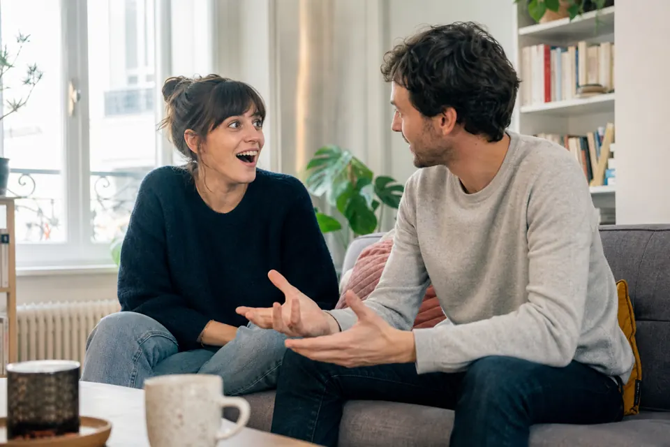 Couple échangeant des réponses sur un canapé