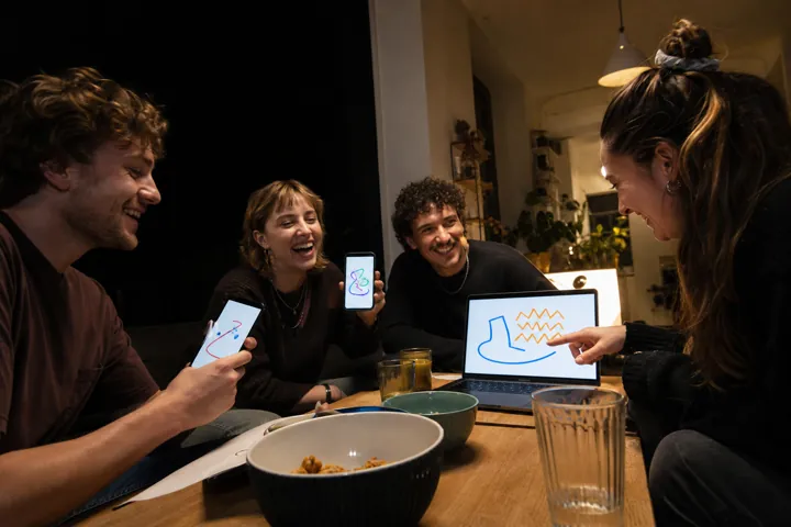 Freunde lachen bei einem Zeichen- und Ratespiel