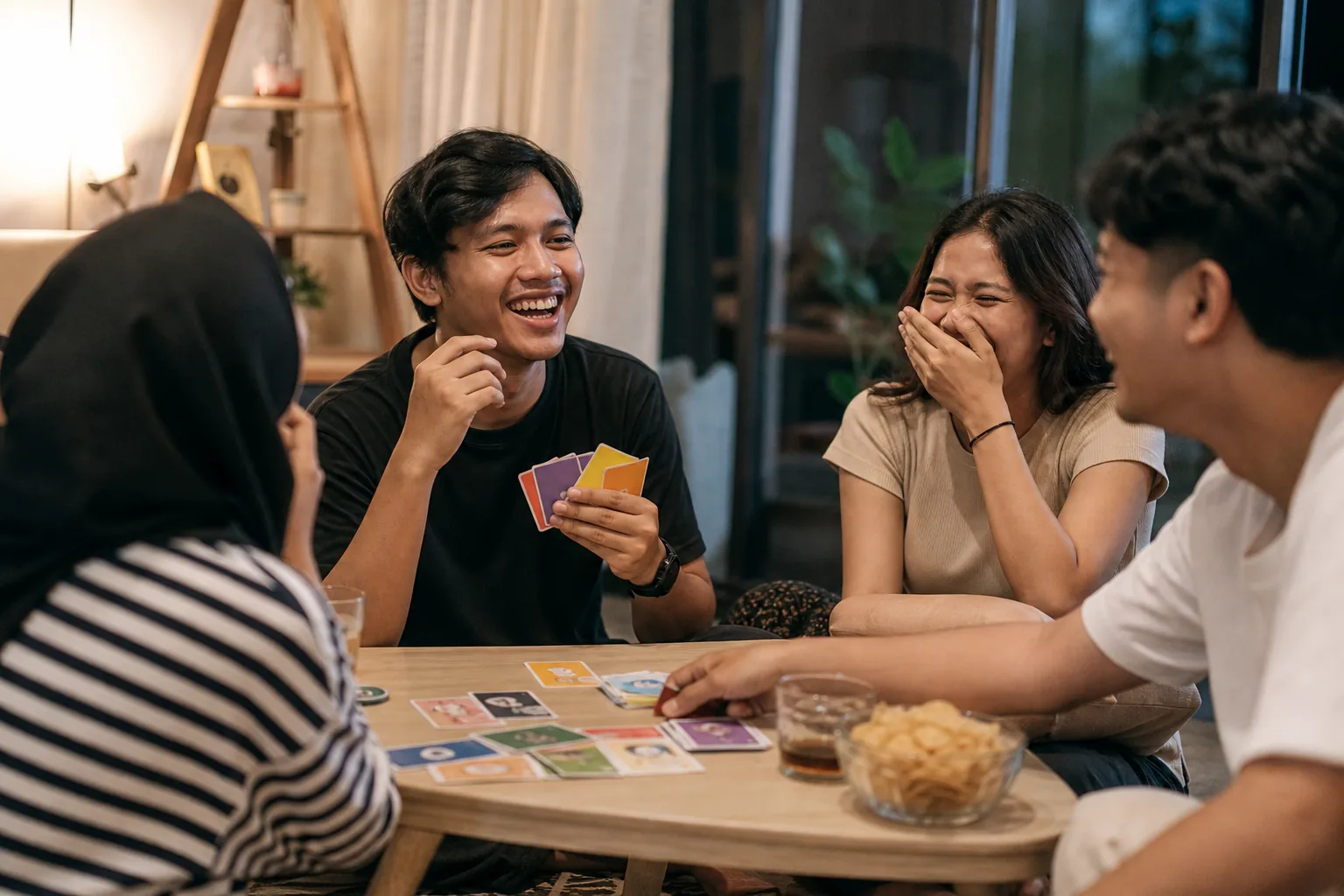 Grup teman Indonesia tertawa saat bermain game pesta