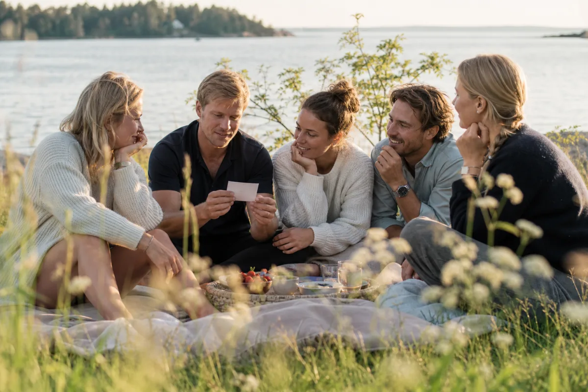 Vänner med frågekort vid vattnet