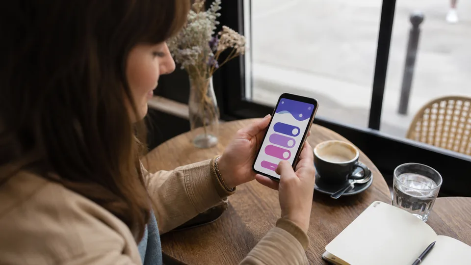 Femme préparant un jeu de couple sur son smartphone dans un café parisien