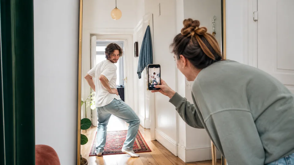 Jeune couple réalisant un défi photo amusant pour WhatsApp