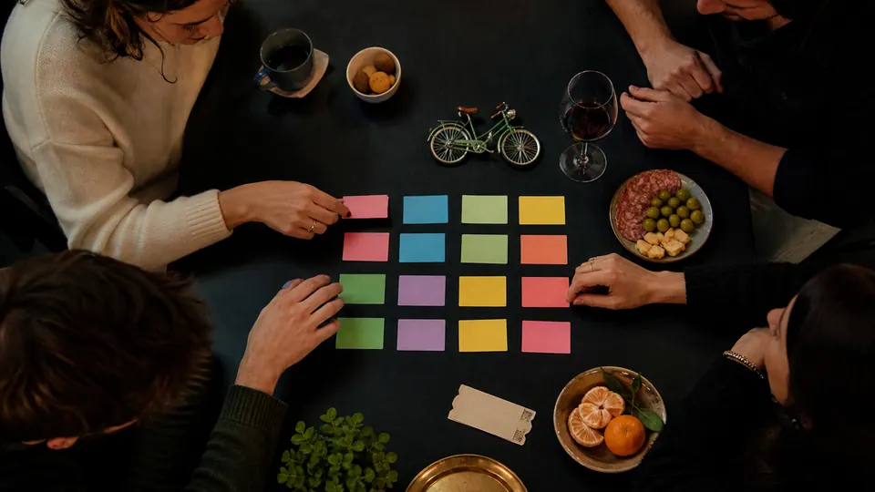 Des amis associent des cartes colorées pour préparer les mots du jeu