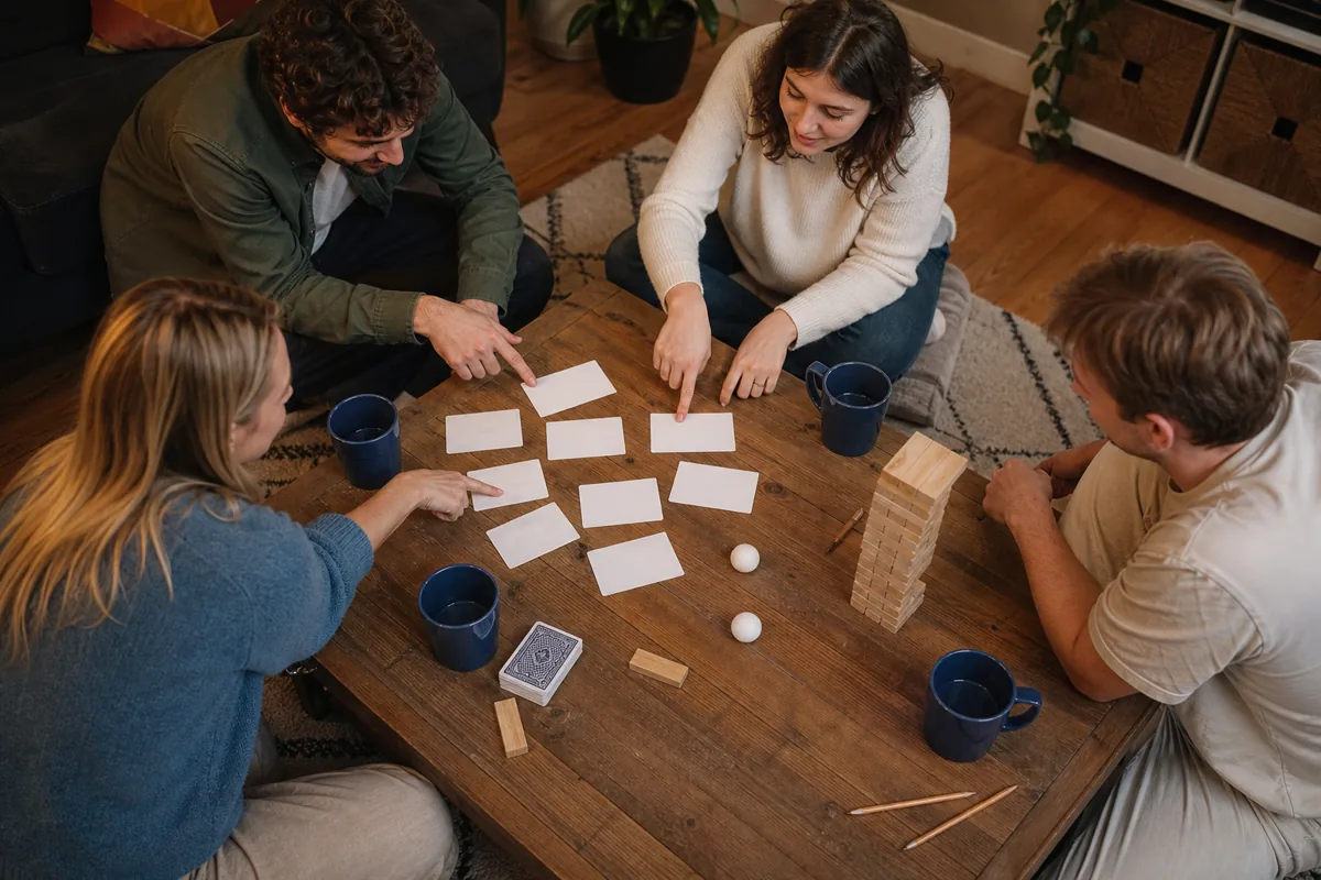 Groupe d’amis choisissant un jeu autour d’une table