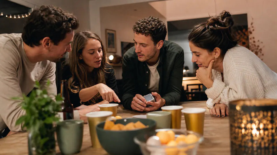 Groupe choisissant un jeu à boire autour d’une table
