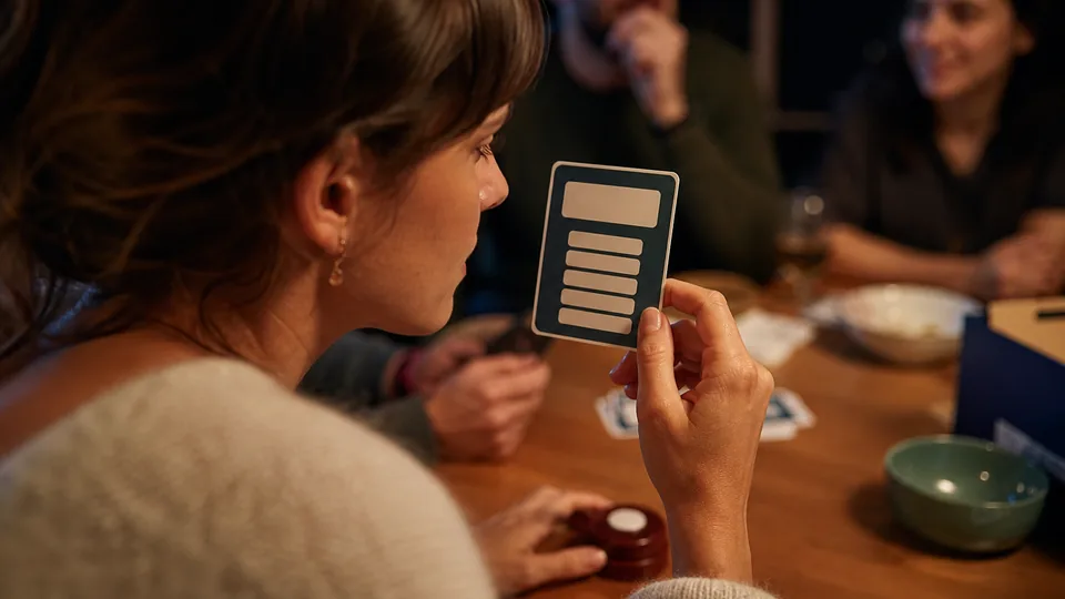 Joueuse vérifiant les mots interdits sur une carte Tabou