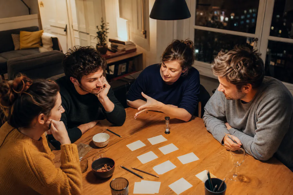 Amis choisissant un jeu autour d’une table