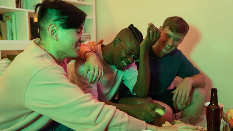 Drie vrienden die lachen aan een tafel