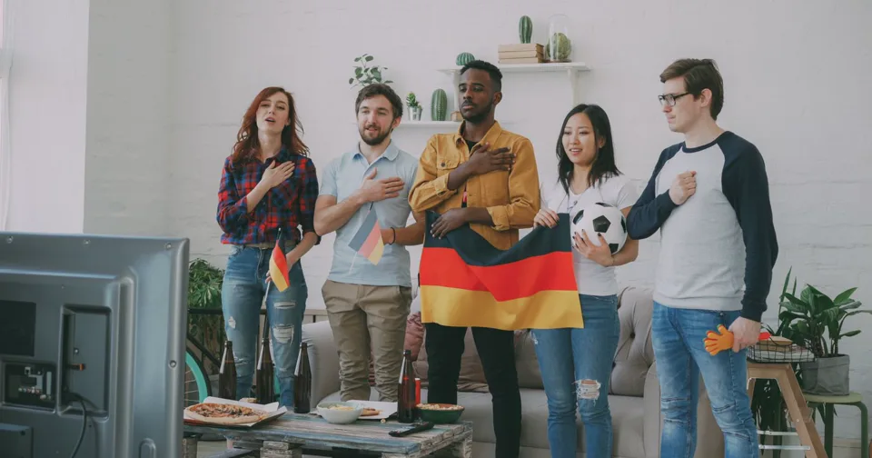 Freundesgruppe unterstützt die deutsche Mannschaft vor einem Fernseher
