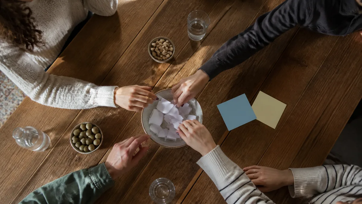 Amis tirant au sort les équipes autour d’une table
