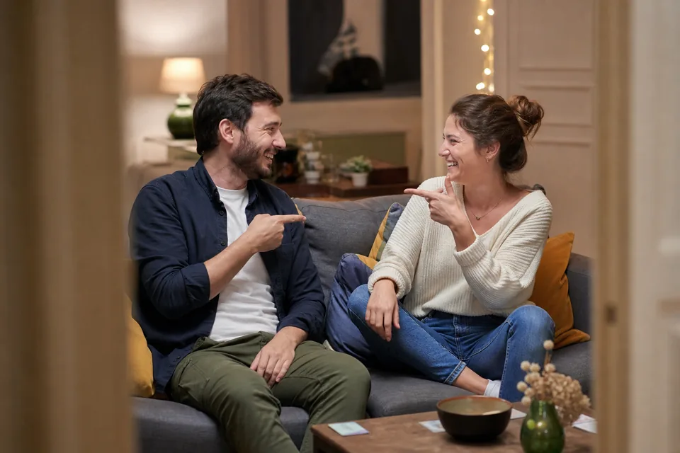 Couple français se désignant en riant