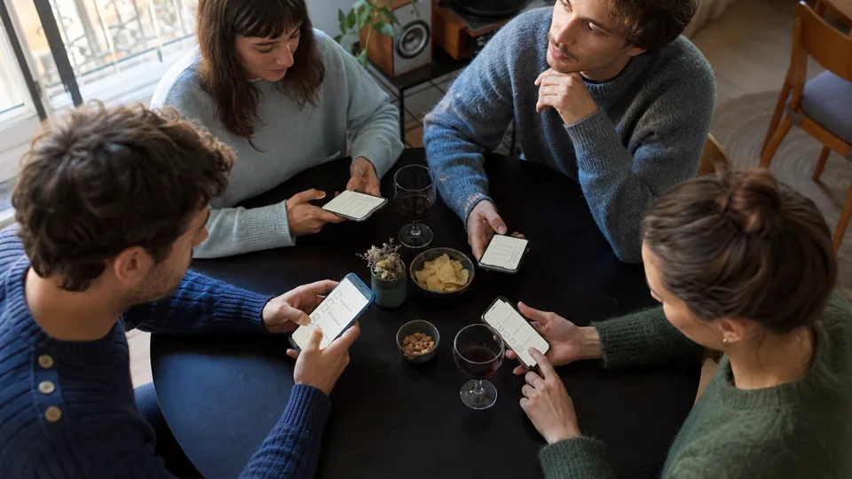 Groupe d’amis répondant séparément à un quiz sur téléphone