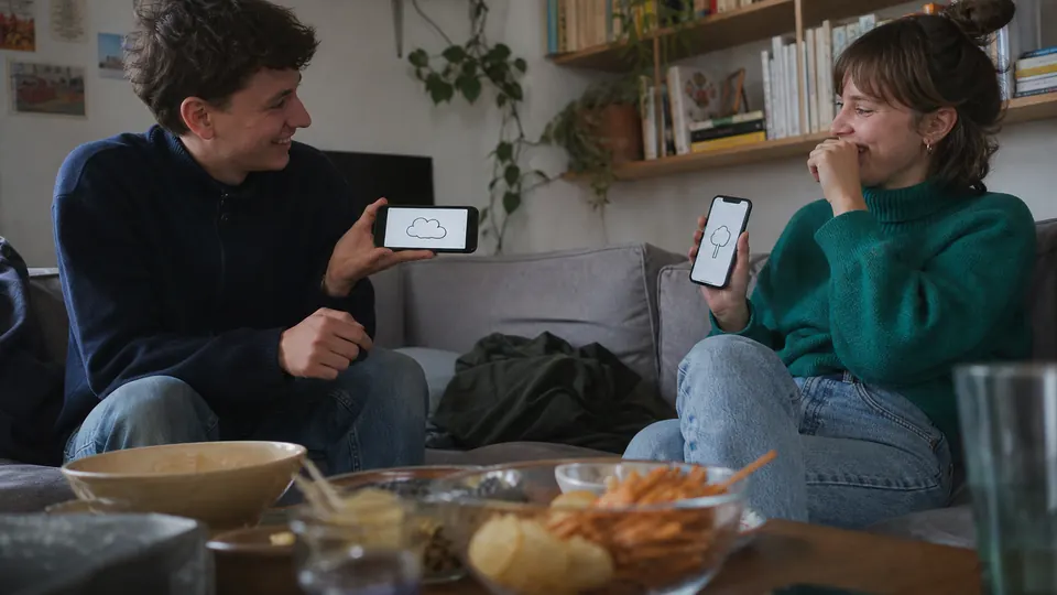 Zwei Freunde zeigen sich gezeichnete Begriffe auf ihren Smartphones