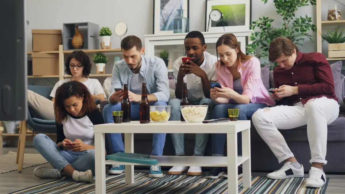 Venner som spiller mobilspill hjemme sammen