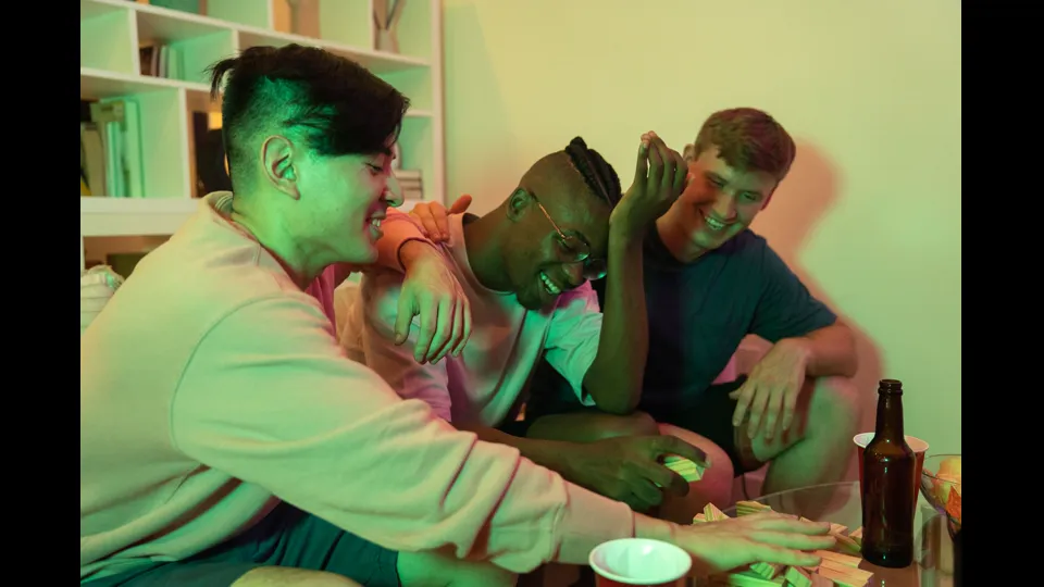 Drie vrienden lachen tijdens een bordspelavond